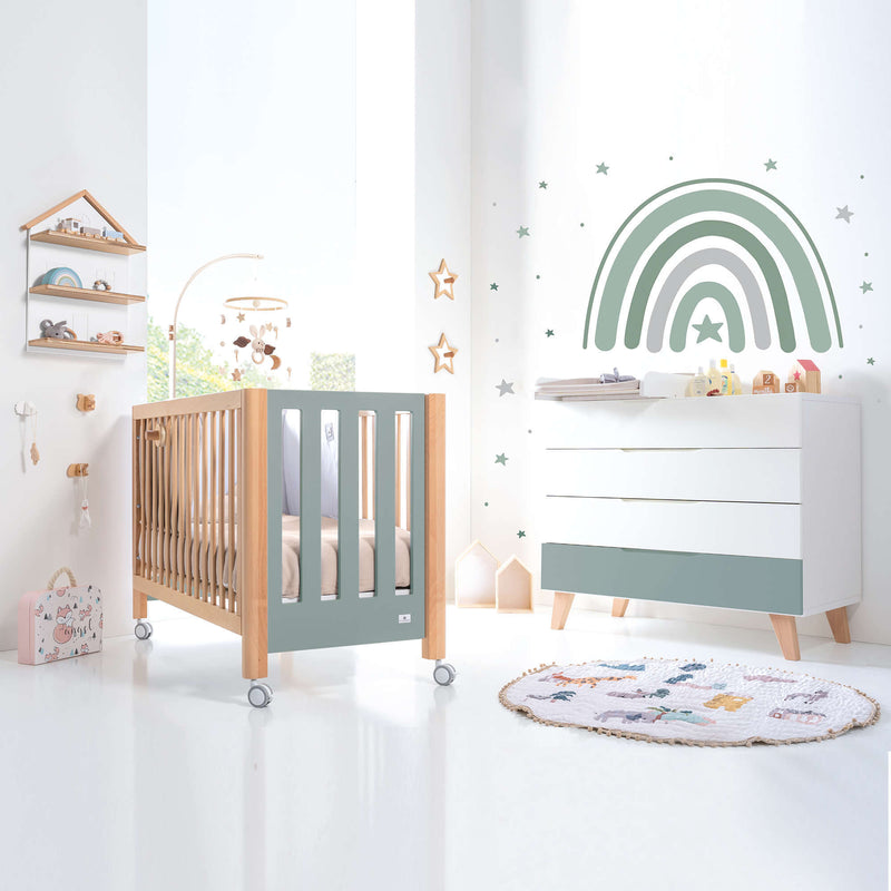 Habitación infantil con cuna y cómoda en verde y madera