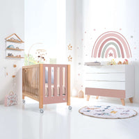 Habitación infantil con cuna y cómoda en rosa y madera