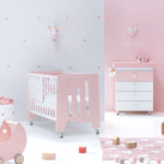 Cuna bebé rosa convertible en escritorio infantil con bañera y vestidor estampado